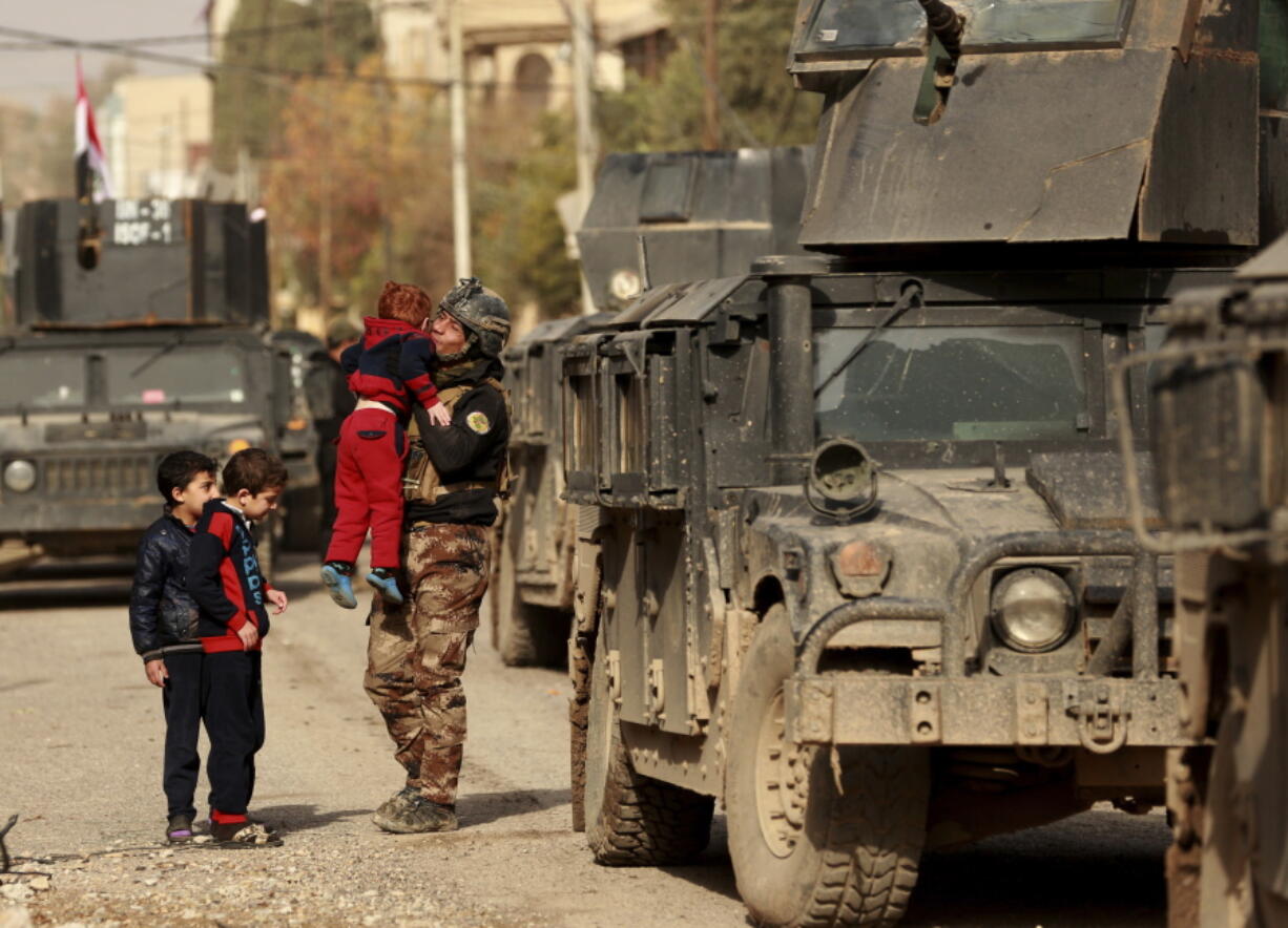 Children welcome Iraqi special forces after they regained control of the Mishraq neighborhood from Islamic State militants Friday in Mosul, Iraq.