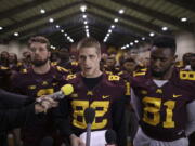 Minnesota wide receiver Drew Wolitarsky, flanked by quarterback Mitch Leidner, left, and tight end Duke Anyanwu stands in front of other team members as he reads a statement.  The players delivered a defiant rebuke of the university&#039;s decision to suspend 10 of their teammates, saying they would not participate in any football activities until the school president and athletic director apologized and revoked the suspensions.