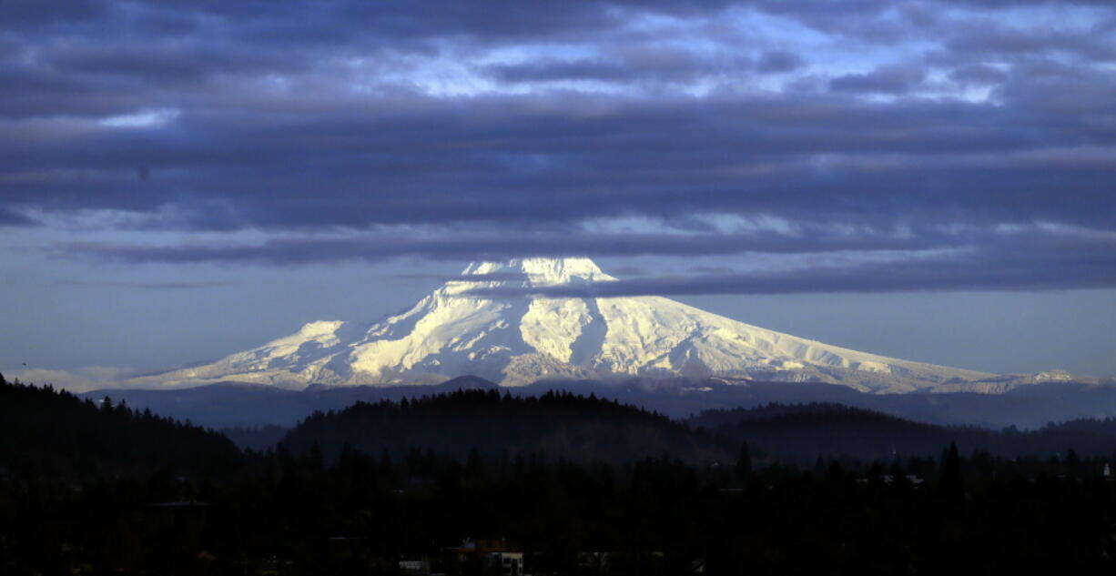 Oregon's Mount Hood sports a fresh coat of snow as the sun sets over Portland. Monitors call state snowpack levels promising for the time of year.