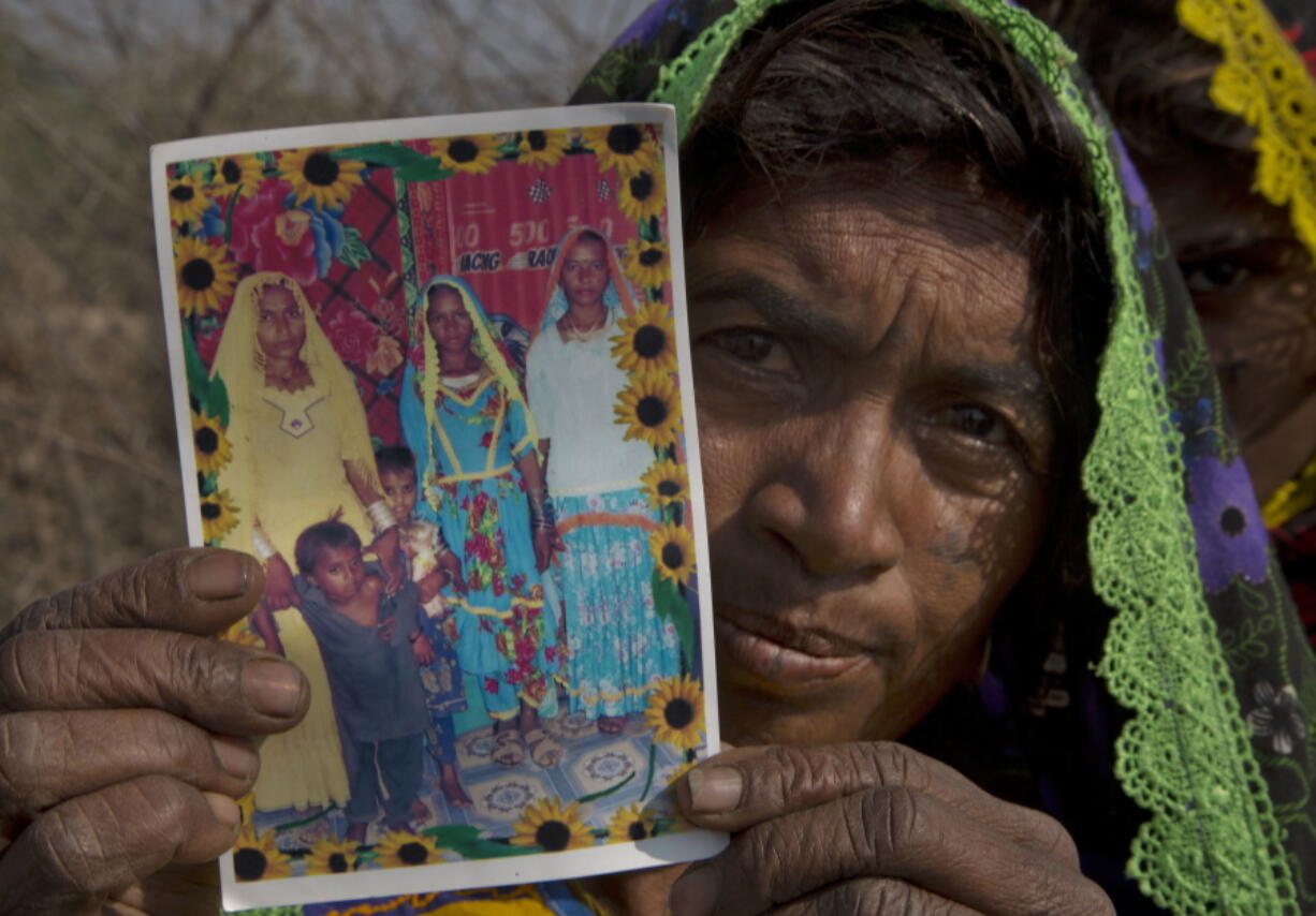 In this photo taken on Thursday, Dec. 1, 2016, Ameri Kashi Kolhi shows picture of her daughter Jeevti, right, in Payro Lundh, Pakistan. The night Jeevti disappeared, her family slept outside to escape Pakistan&#039;s brutal summer heat; in the morning she was gone, snatched by a wealthy landlord to whom her parents owed $1,000 dollars. She is one of the estimated 1,000 Christian and Hindu girls taken from their homes every year in Pakistan for supposed repayments of debt, most of them ending up married off to older men and forcibly converted to Islam.(AP Photo/B.K.