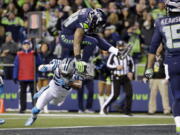 Seattle Seahawks&#039; Thomas Rawls (34) leaps over Carolina Panthers&#039; Daryl Worley to score a touchdown in the first half of an NFL football game, Sunday, Dec. 4, 2016, in Seattle. (AP Photo/Ted S.