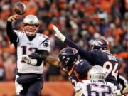 New England Patriots quarterback Tom Brady passes under pressure against the Denver Broncos during the second half of an NFL football game Sunday, Dec. 18, 2016, in Denver.