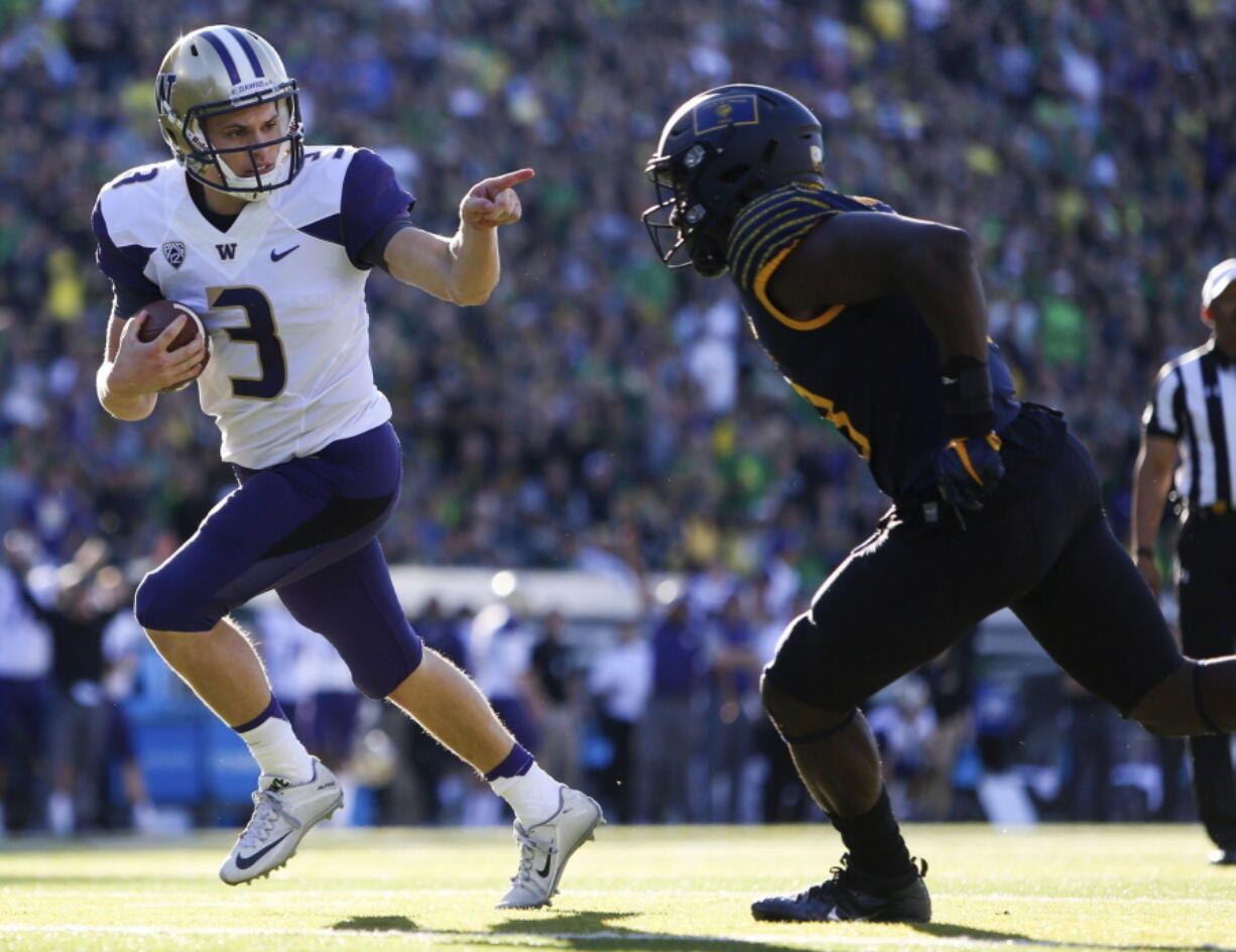 Washington quarterback Jake Browning points to Oregon&#039;s Jimmie Swain while rushing for a touchdown Oct. 8 in Eugene, Ore. It was so out of character it became the defining moment of his time at Washington.