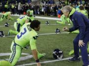 Seattle Seahawks head coach Pete Carroll, right, talks with quarterback Russell Wilson (3) before an NFL football game against the Los Angeles Rams, Thursday, Dec. 15, 2016, in Seattle.