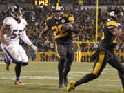 Pittsburgh Steelers running back Le&#039;Veon Bell (26) heads for the end zone past Baltimore Ravens outside linebacker Terrell Suggs (55) for a touchdown during the second half of an NFL football game in Pittsburgh, Sunday, Dec. 25, 2016.