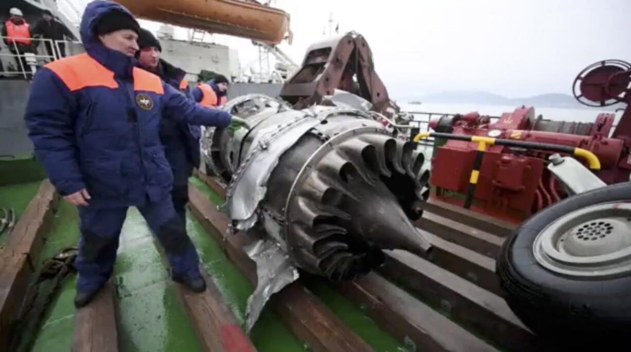 Employees examine a fragment of a plane engine lifted by divers on a ship just outside Sochi, Russia. Russia&#039;s Defense Ministry says search teams have recovered another flight recorder from a military plane that crashed in the Black Sea, killing all 92 aboard.