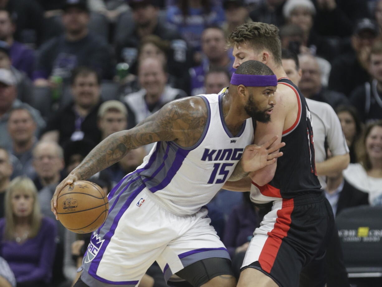 Sacramento Kings forward DeMarcus Cousins, left, goes to the basket against Portland Trail Blazers&#039; Meyers Leonard during the first quarter of an NBA basketball game Tuesday, Dec. 20, 2016, in Sacramento, Calif.