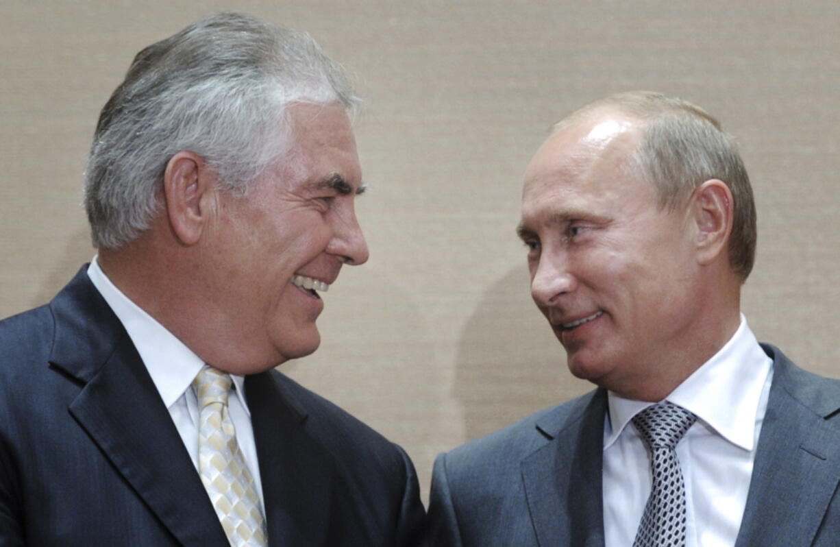 FILE- In this Aug. 30, 2011, file photo, Russian Prime Minister Vladimir Putin, right, and Rex Tillerson, ExxonMobil&#039;s chief executive smile during a signing ceremony in the Black Sea resort of Sochi, Russia. President-elect Donald Trump selected ExxonMobil CEO Rex Tillerson to lead the State Department on Monday, Dec. 12, 2016.