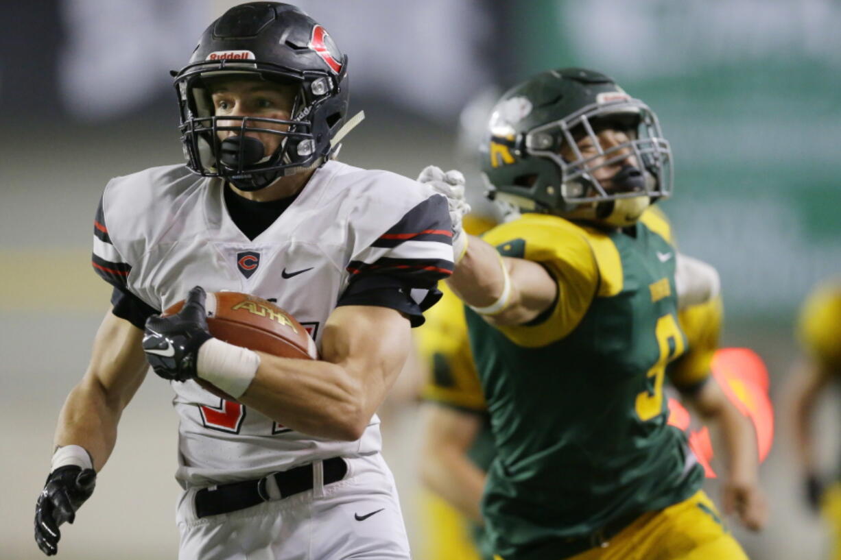 Camas running back Will Schultz, left, escapes the grasp of Richland&#039;s Kyle Kirby, right, to run for a touchdown during the second half of the Washington Div. 4A high school football championship, Saturday, Dec. 3, 2016, in Tacoma, Wash. (AP Photo/Ted S.