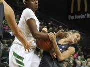 Oregon's Ruthy Hebard, left, fights for possession of the ball against Washington's Heather Corral during an NCAA college basketball game Friday, Dec. 30, 2016, in Eugene, Ore.