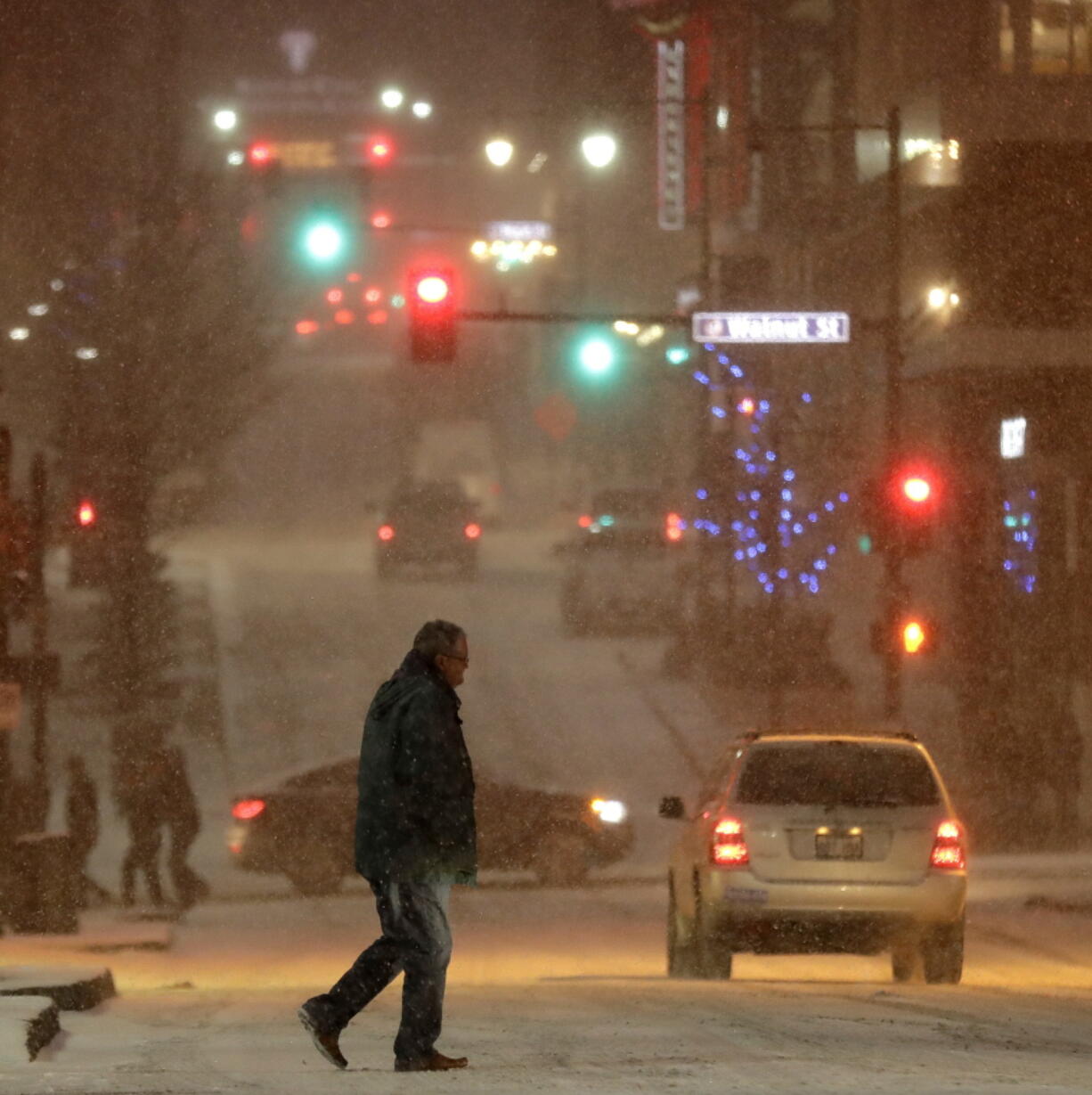 A pedestrian walks across a street Saturday in downtown Kansas City, Mo.