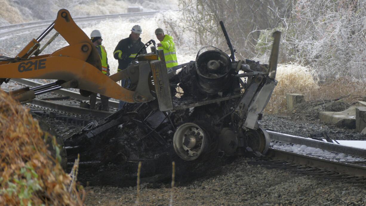 Seen from the Interstate 95 overpass from Grove Street in southwest Baltimore, Md., emergency workers extract the wreckage of a tractor trailer from railroad tracks after it fell off a bridge and exploded, in a series of accidents that shut down I-95 on Saturday, Dec. 17, 2016. An ice storm created slick conditions, sparking a chain reaction pile-up involving dozens of vehicles.