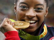 United States' Simone Biles bites her gold medal for the artistic gymnastics women' individual all-around final at the 2016 Summer Olympics in Rio de Janeiro, Brazil. Briles was selected as the AP Female Athlete of the Year, on Monday, Dec. 26, 2016.