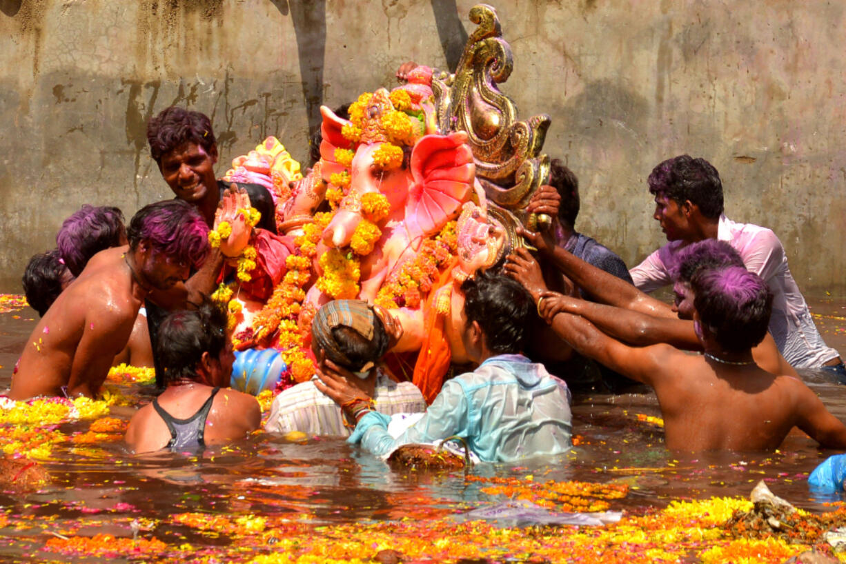 Indian devotees immersing the Hindu god Ganesha during Ganesh Chaturthi, a popular 11-day religious festival annually celebrated across India.