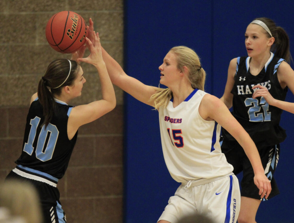 Ridgefield forward Kaia Oliver, right, knocks the ball away from Hockinson forward Adyson Dyer during the Spudders&#039; 39-26 win.