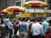 Customers stand in line at The Halal Guys&#039; food cart Sept. 9 in New York.