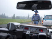 Washington State Patrol Trooper Nick Jennings walks back to his cruiser after citing a driver for speeding in east Vancouver in 2010.