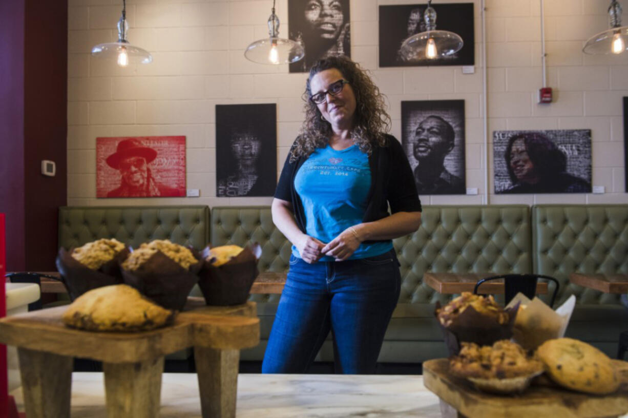 Faith Holmes, owner of Love &#039;n Faith Community Cafe, at her cafe in front of the exhibition &quot;Given a Voice,&quot; a collection of work by students from the Duke Ellington School of the Arts Museum Studies Department in Washington.