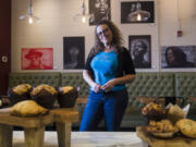 Faith Holmes, owner of Love &#039;n Faith Community Cafe, at her cafe in front of the exhibition &quot;Given a Voice,&quot; a collection of work by students from the Duke Ellington School of the Arts Museum Studies Department in Washington.