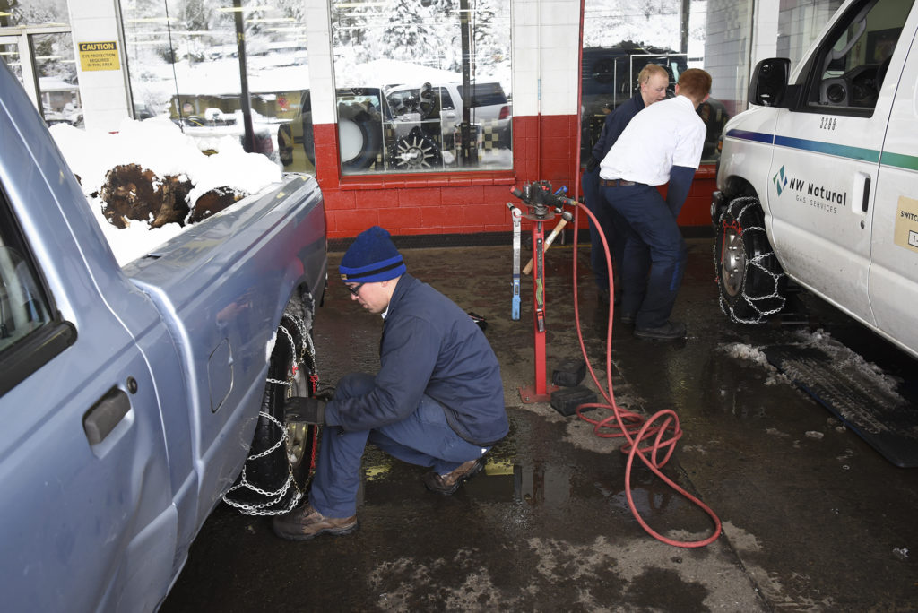 Les Schwab employees put chains on a vehicles at the Les Schwab in Hazel Dell in 2017.