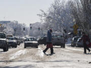 Pedestrians and motorists navigate a slushy, thawing Main Street in Uptown Village on Thursday afternoon.