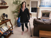 Debra Weidner, who has multiple sclerosis, uses a cane to move around her home in Camas. Weidner is traveling to Mexico in March for a hematopoietic stem cell transplant to treat her MS.