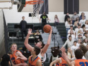 Woodland’s Palmer Dinehart (4) prepares to make a shot past Ridgefield’s Kellen Bringhurst (33) and Louden Wardius (43) during the third quarter at Woodland High School, Tuesday January 31, 2017.