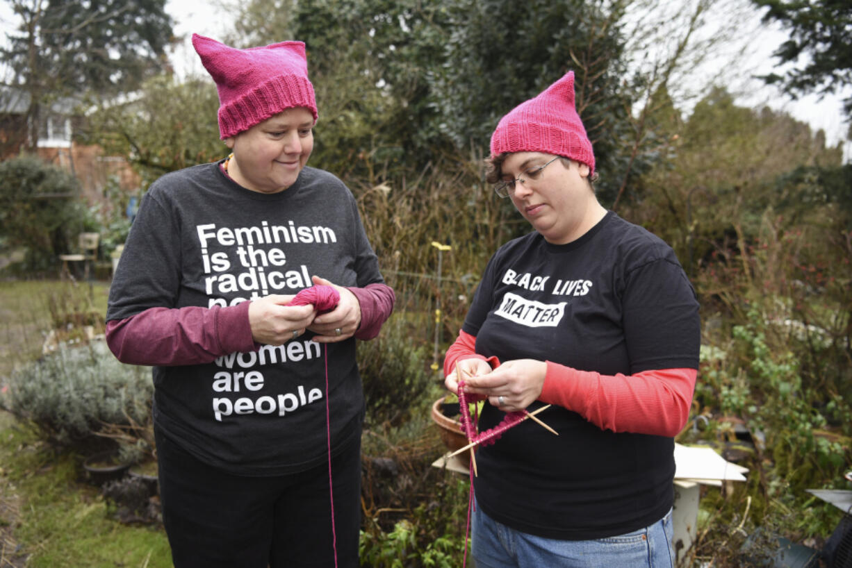 Sam MacKenzie, right, knits a pussyhat with the help of her wife, Kelly Keigwin, at their home in Vancouver on Jan. 10.