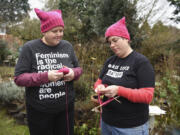 Sam MacKenzie, right, knits a pussyhat with the help of her wife, Kelly Keigwin, at their home in Vancouver on Jan. 10.