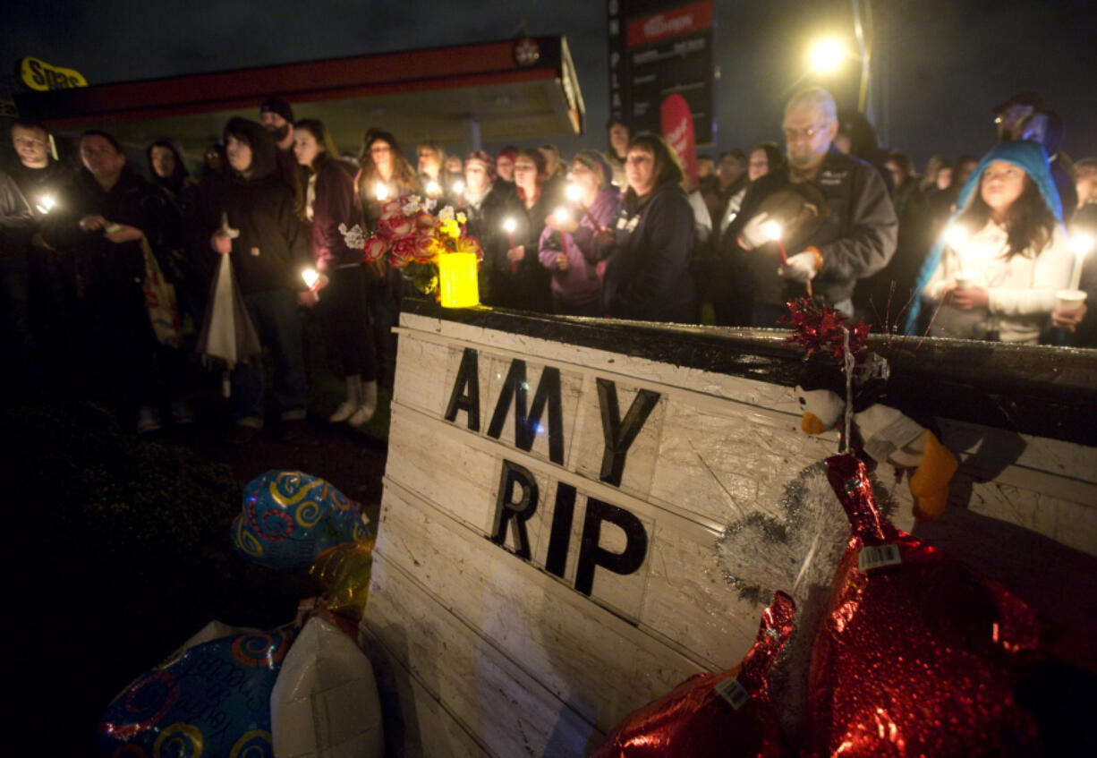 Mourners attend a vigil for slain community resident Amy Hooser in Vancouver on Saturday.