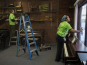 Volunteers Stacey Hewitt, left, and Dawana Sadler of Kaiser Permanente help dust and clean windows Monday morning at the School of Piano Technology for the Blind in Vancouver.