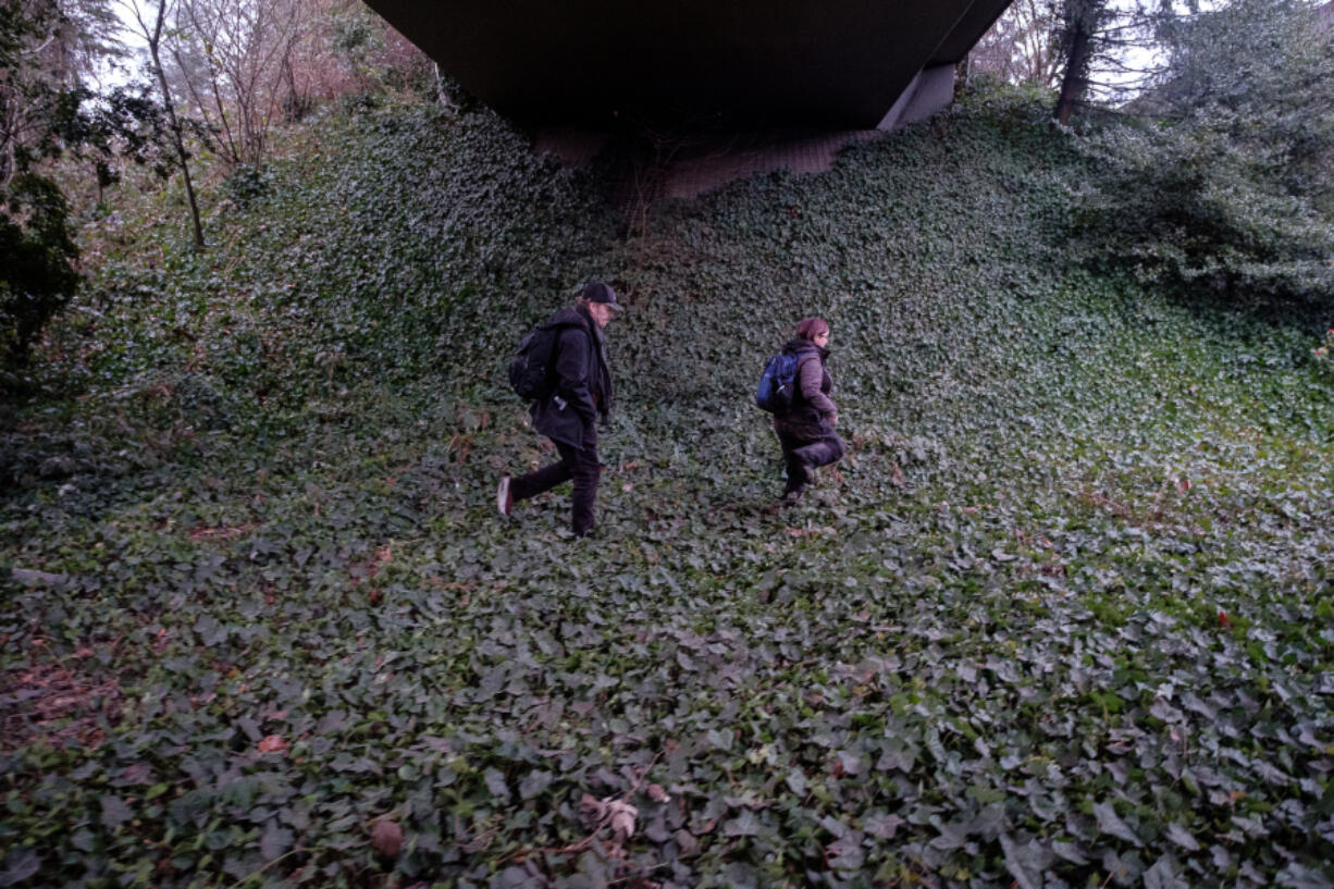 Community Service Northwest caseworkers Jamie Spinelli, left, and Thomas Eaton walk under an overpass during the annual Point-in-Time count that attempts to count all of the homeless people.