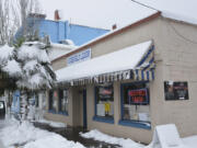 A snow-covered palm tree outside of Ridgefield Liquor, which saw a steady stream of people looking to stock up on alcohol Wednesday.