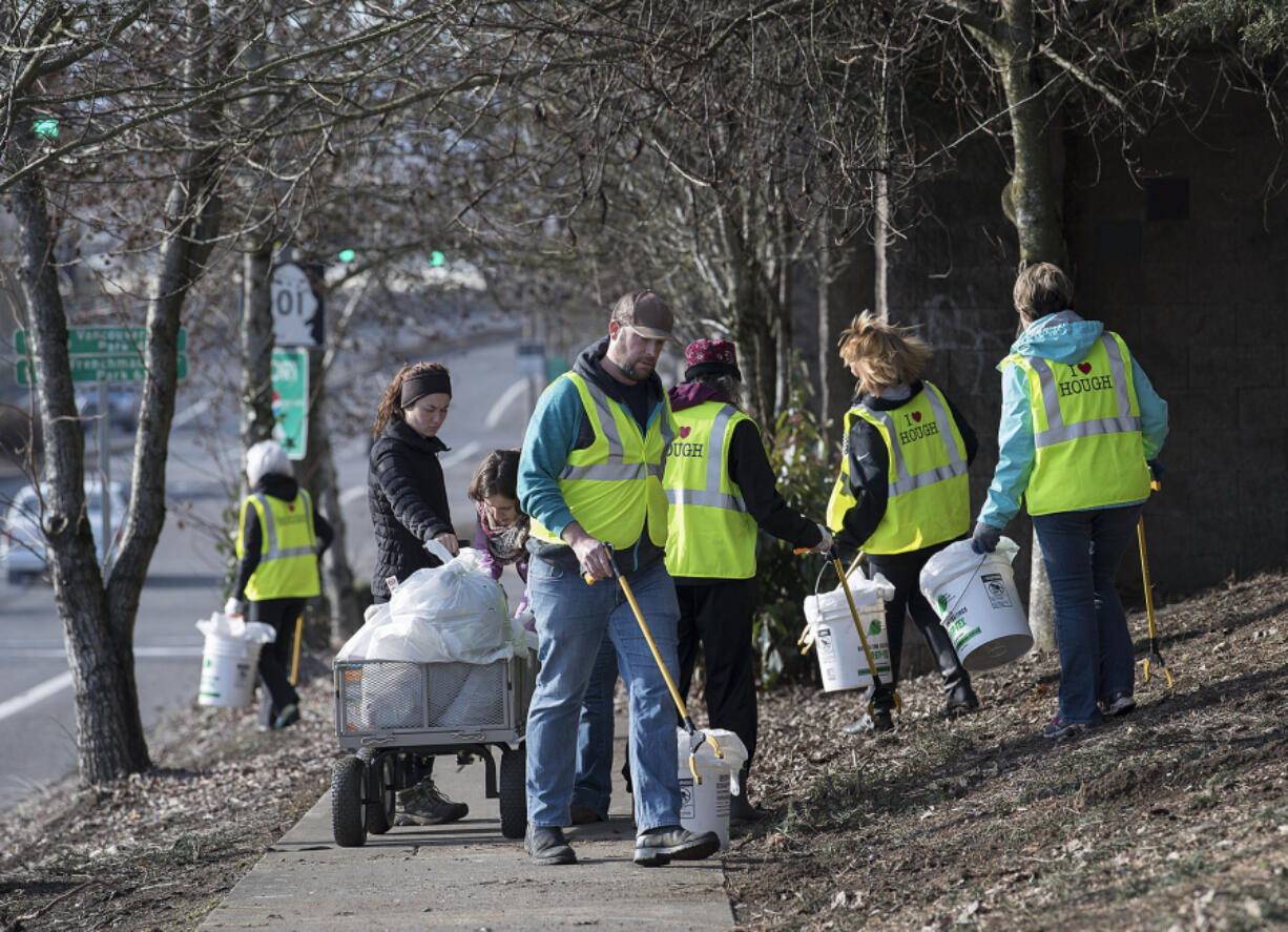 Volunteer Tim North, center, picks up trash along Mill Plain Boulevard with other residents of the Hough neighborhood on Jan. 23.