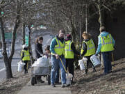 Volunteer Tim North, center, picks up trash along Mill Plain Boulevard with other residents of the Hough neighborhood on Jan. 23.