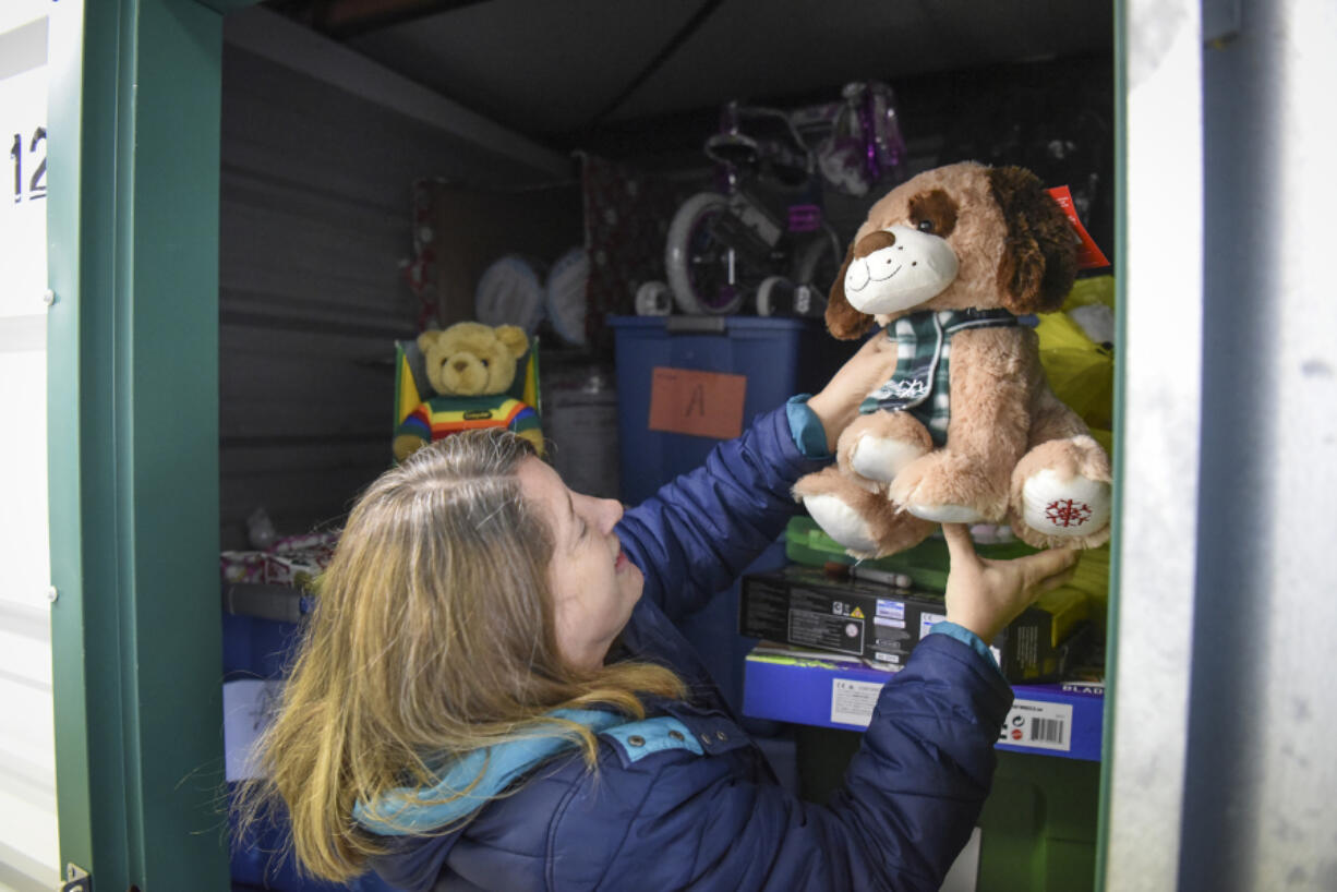 Vicki Fitzsimmons, co-chair for the Holiday Youth Giving Event, organizes toys in a storage unit at Salmon Creek Mini Storage in Vancouver. The storage unit, filled to the ceiling with children&#039;s gifts donated by the community, will be distributed to children in need at the Holiday Youth Giving Event on Thursday.