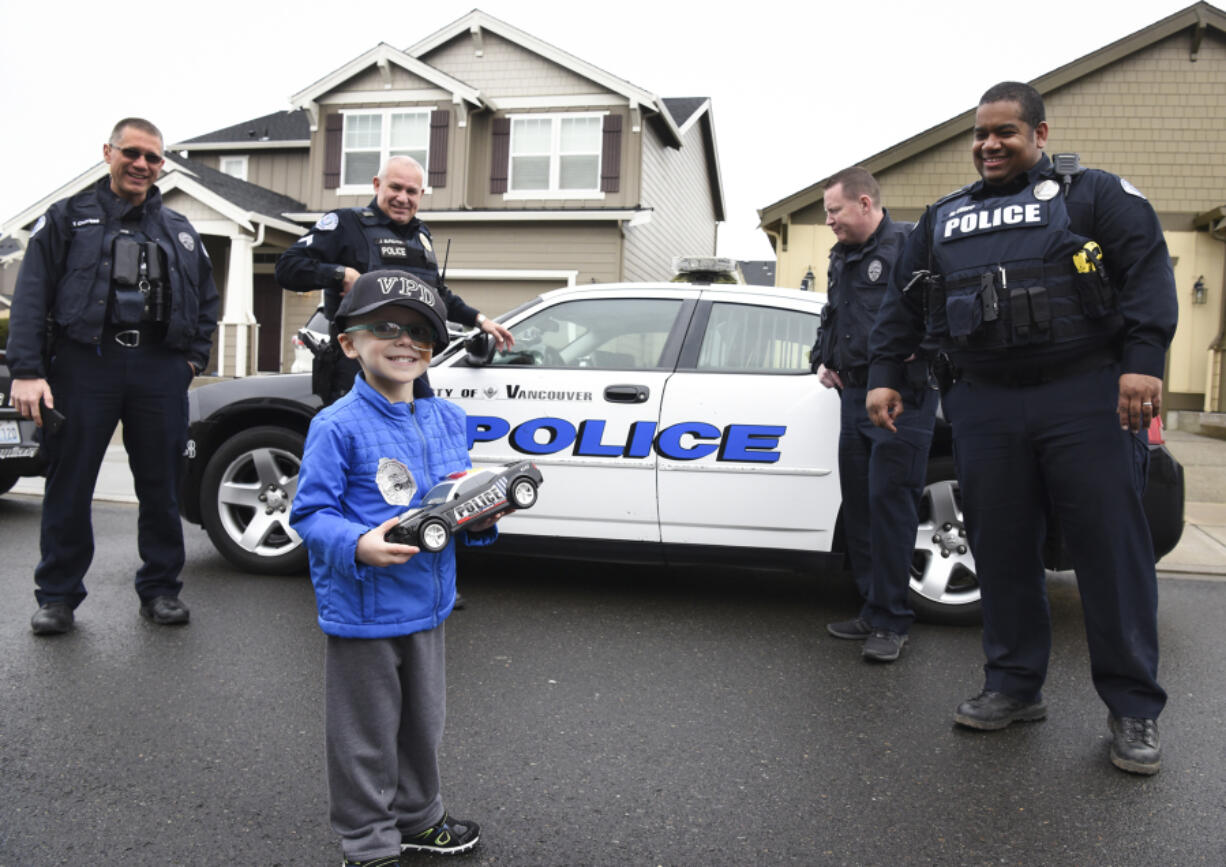 Nick Zadak, 4, who is battling pediatric liver cancer, smiles back at his mom before getting into a police car for a ride-along with Vancouver police officers Tyler Chavers, left, James Burgara, Erik Jennings and Mac Shipp at Nick&#039;s home in Vancouver on Wednesday.