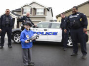 Nick Zadak, 4, who is battling pediatric liver cancer, smiles back at his mom before getting into a police car for a ride-along with Vancouver police officers Tyler Chavers, left, James Burgara, Erik Jennings and Mac Shipp at Nick&#039;s home in Vancouver on Wednesday.