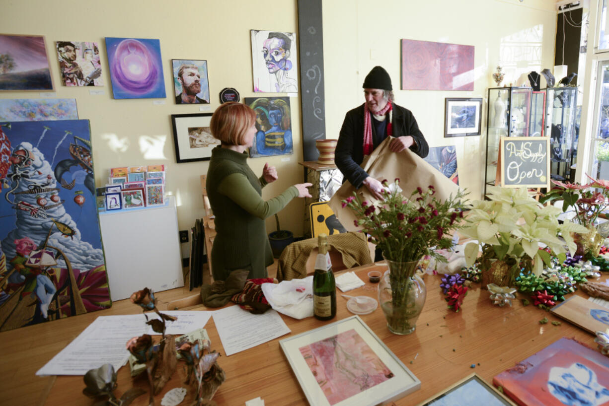 Leah Jackson the owner of Angst Gallery in Vancouver, left, helps local artist Greg Bye submit a piece of artwork for the January exhibit, &quot;The Male Form.&quot; (Photos by Ariane Kunze/The Columbian)