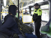 Ethan Greagor, left, talks with Max Wajda, a C-Tran fare compliance officer, while riding The Vine. The compliance officers will check for tickets, which are bought in advance, not from the driver.