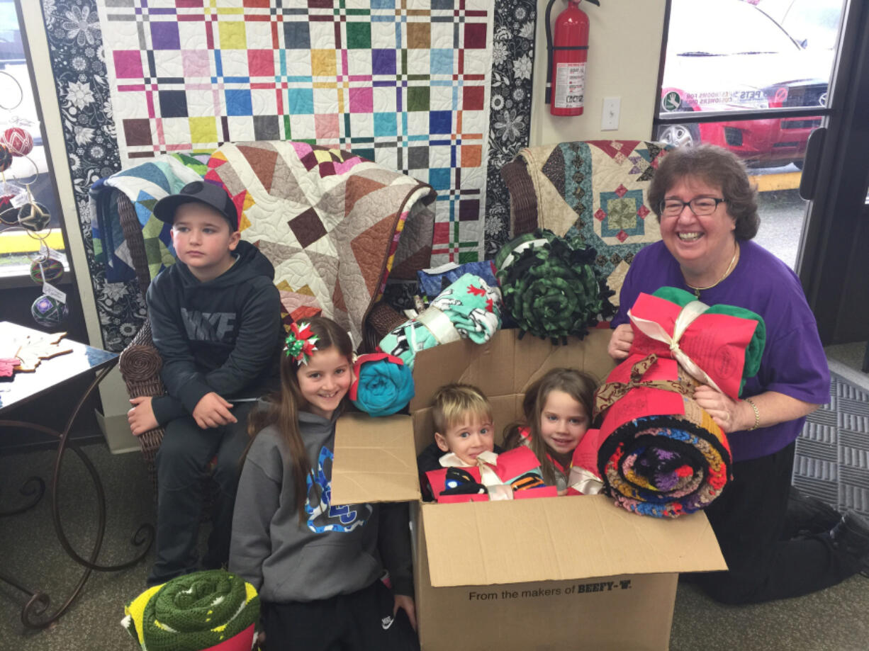 La Center: La Center Elementary School third-grader Leif Hasselblad, from left, third-grader Adyson Maddock, kindergartner Soren Hasselblad and first-grader Sophi Hasselblad join Jodene Cook, Clark County coordinator of Project Linus, packing some of the 54 blankets the school collected at its first Blanket Drive.