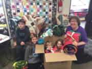 La Center: La Center Elementary School third-grader Leif Hasselblad, from left, third-grader Adyson Maddock, kindergartner Soren Hasselblad and first-grader Sophi Hasselblad join Jodene Cook, Clark County coordinator of Project Linus, packing some of the 54 blankets the school collected at its first Blanket Drive.