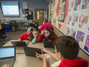 Seventh-grader Jordan Peterson, 12, from left, joins classmates Anna McCready, 12, and Paige Barrett, 13, as they use their Dell Chromebooks to work on a project at Chief Umtuch Middle School in Battle Ground on Thursday morning. The district is putting a levy before voters on Feb. 14. Part of the funding supports technology in classrooms.