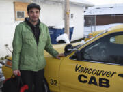 Taxi driver Jason Coffield stands outside a taxi at Vancouver Cab on Thursday evening.