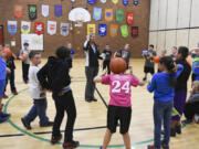 Parent volunteer Julie Perry, center, directs Burnt Bridge Creek Elementary School students in their basketball club on Dec. 1 during an after-school program. The east Vancouver school in the Evergreen Public Schools district has phased out traditional homework and replaced it with after-school clubs.