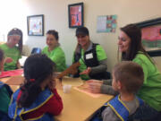 Central Vancouver: Kaiser Permanente employees Rowan Shank, from left, Susan Luna, Glenna Thompson and Marion Brit help with crafts in the Early Learning Center at Innovative Services NW, one of seven locations where Kaiser employees spent time volunteering in honor of Martin Luther King Day of Service.