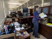 Community engagement staff officer Tracy Calizon unpacks boxes at her new desk at Fort Vancouver National Historic Site east Vancouver Barracks. (Amanda Cowan/The Columbian)