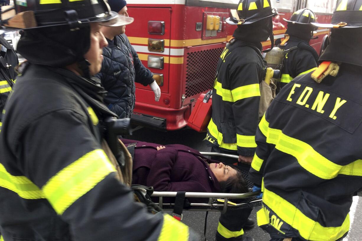 An injured passenger is taken on a gurney by firefighters from Atlantic Terminal in the Brooklyn borough of New York after a Long Island Rail Road train hit a bumping block, Wednesday, Jan. 4, 2017.