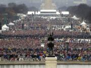 People stand on the National Mall to listen to the 58th Presidential Inauguration for President Donald Trump at the U.S. Capitol in Washington, Friday, Jan. 20, 2017.