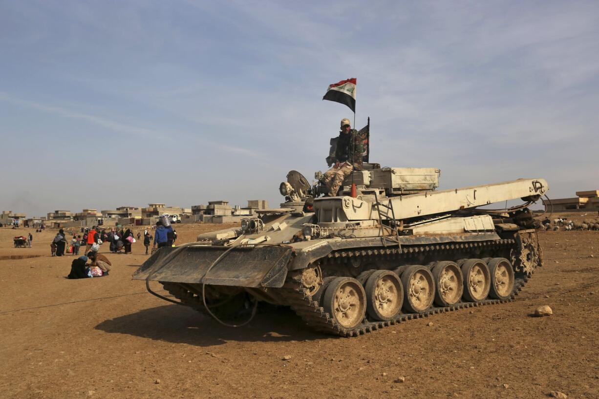 Iraqi Army vehicles advance as civilians flee their villages due to fighting between Iraqi security forces and Islamic State militants, on the outskirts of Mosul, Iraq, Thursday, Jan. 26, 2017.